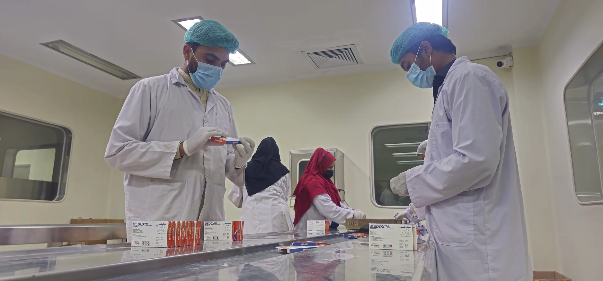 HiMedic personnel managing pharmaceutical packaging on a controlled production line